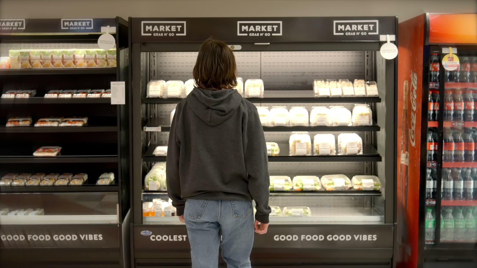 A student at the Market Grab n Go fridges, under headers reading Good food good vibes