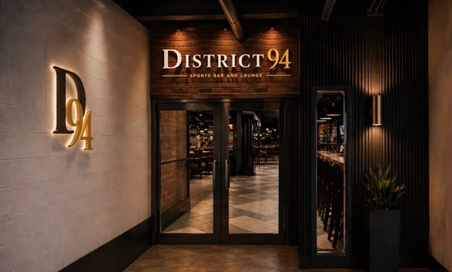Visualisation of the District 94 entrance: the backlit D94 monogram on a pale wall and the sign over glass doors