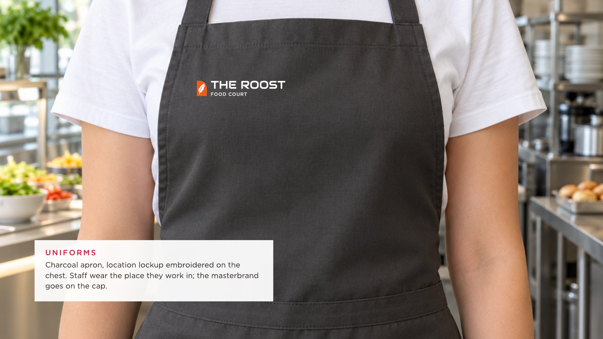Concept render: charcoal apron with The Roost lockup on the chest